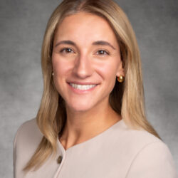 Professional headshot of a smiling woman with blonde hair.